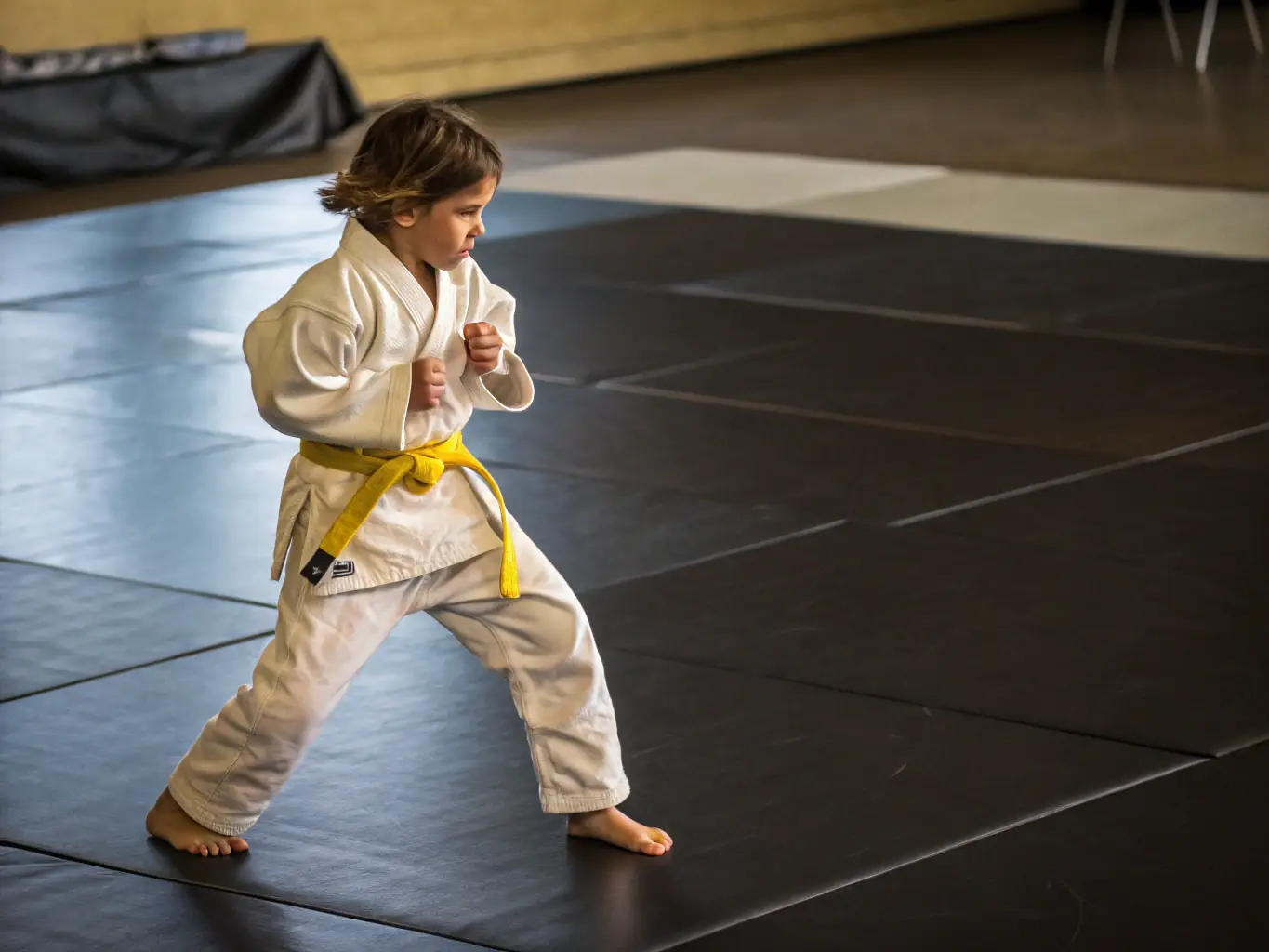 A young student confidently demonstrating a jujitsu technique, highlighting the development of self-discipline and focus.