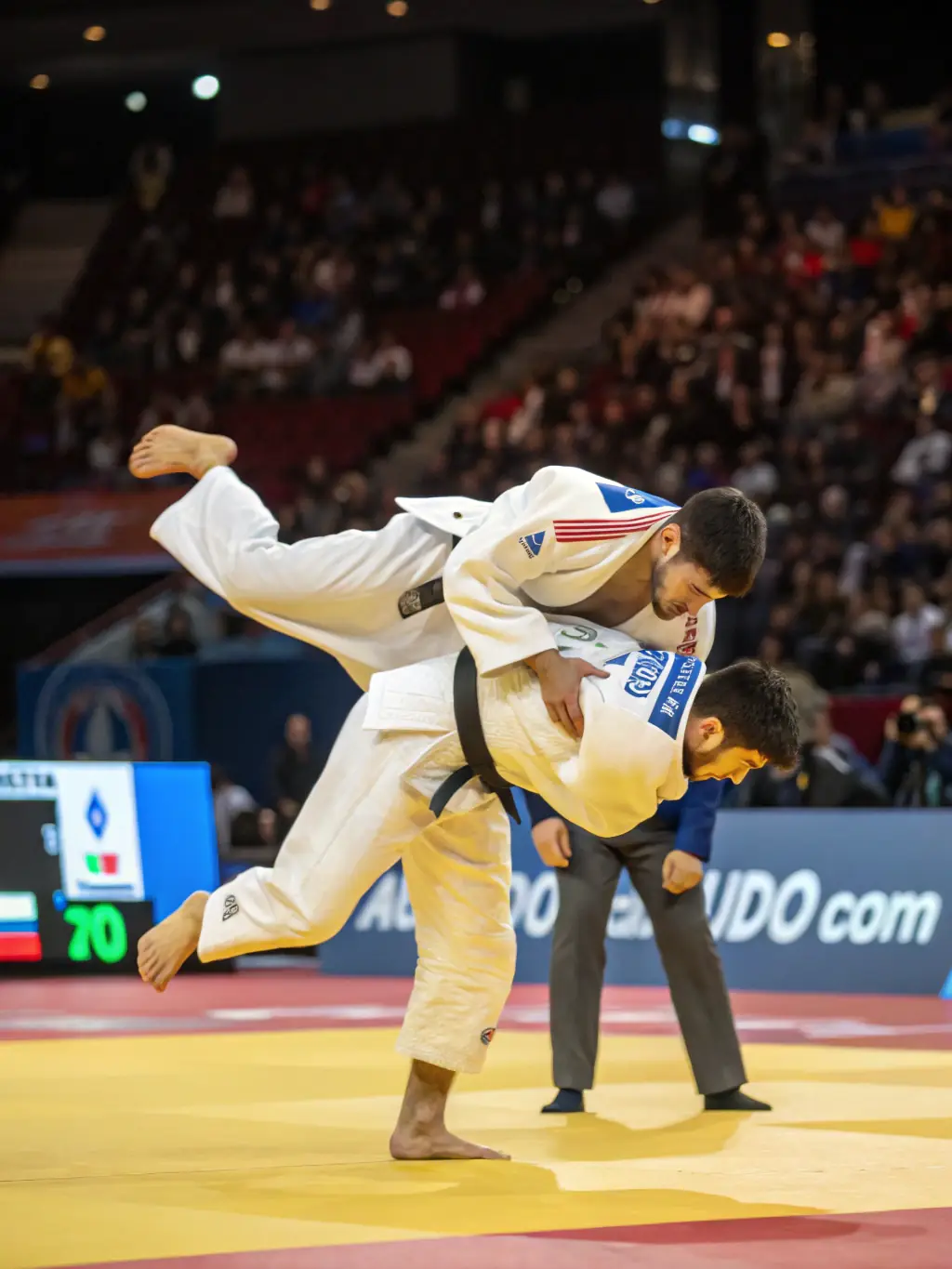 A dynamic action shot of judo practitioners in white uniforms engaged in a grappling match during a training session at AJAC ALLIANCE JUDO AURILLAC CANTAL, showcasing the intensity and technique involved in judo.